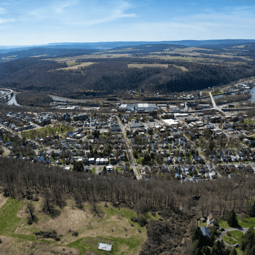 Aerial view of a residential community in Central New York surrounded by hills and countryside.