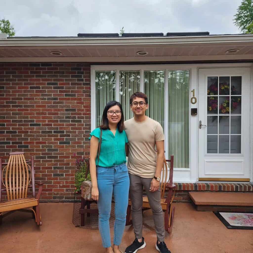 Happy couple standing outside their home after a professional home inspection