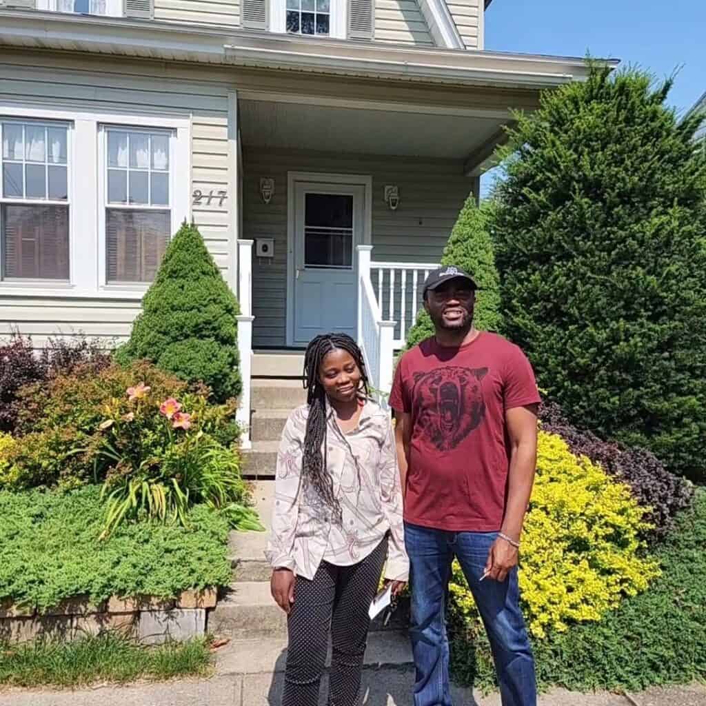 Happy couple standing outside their home after a professional home inspection in Central New York